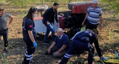 Devrilen traktörün altından sağ çıktı