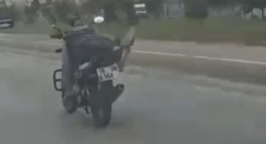 Motosikleti üstüne uzanarak kullanıyor