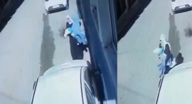 Kucağındaki bebekle battaniye çalan şahıs kamerada