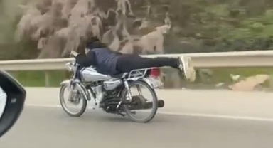 Canını hiçe saydı, motosikletin üzerinde uzanarak seyretti
