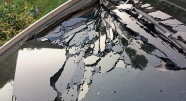 Apartmandan atılan kemik otomobilin tavanını parçaladı