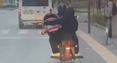 Motosiklet üzerinde bebeği pusetiyle taşıdı