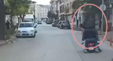 Motosiklete sığmak için sürücünün omzuna çıktı