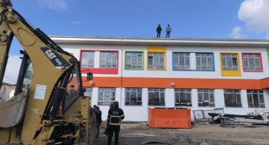 Paralarını alamayan işçiler okulun çatısına çıktı