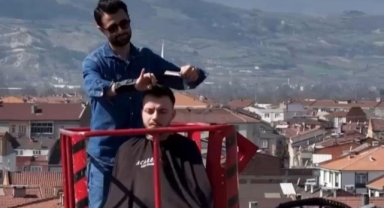 Müşterilerini Bursa manzarasına karşı tıraş etti